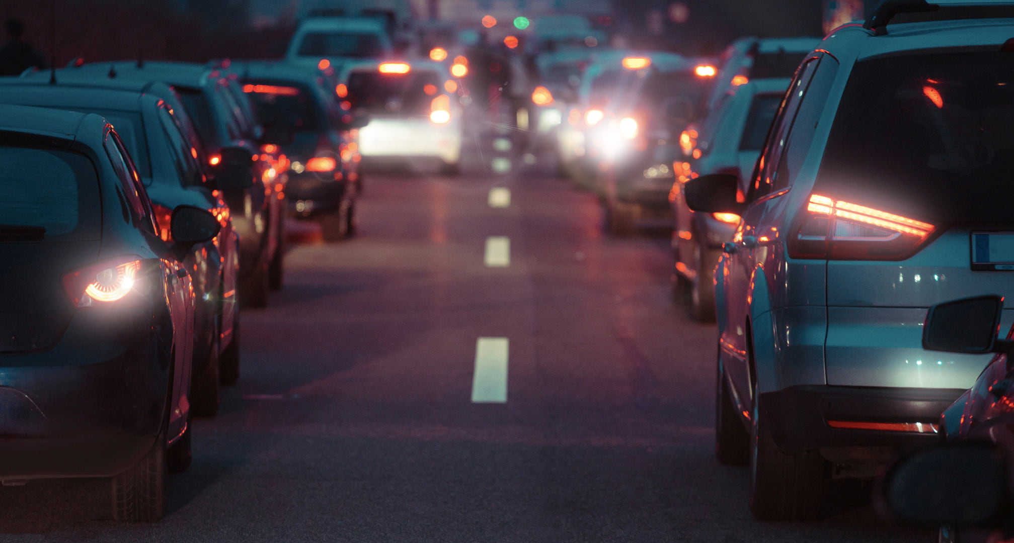 Aloni di luce causati dall'astigmatismo intorno ai fanali posteriori delle auto di notte (sinistra). Luci posteriori di notte viste da un occhio normale (destra).