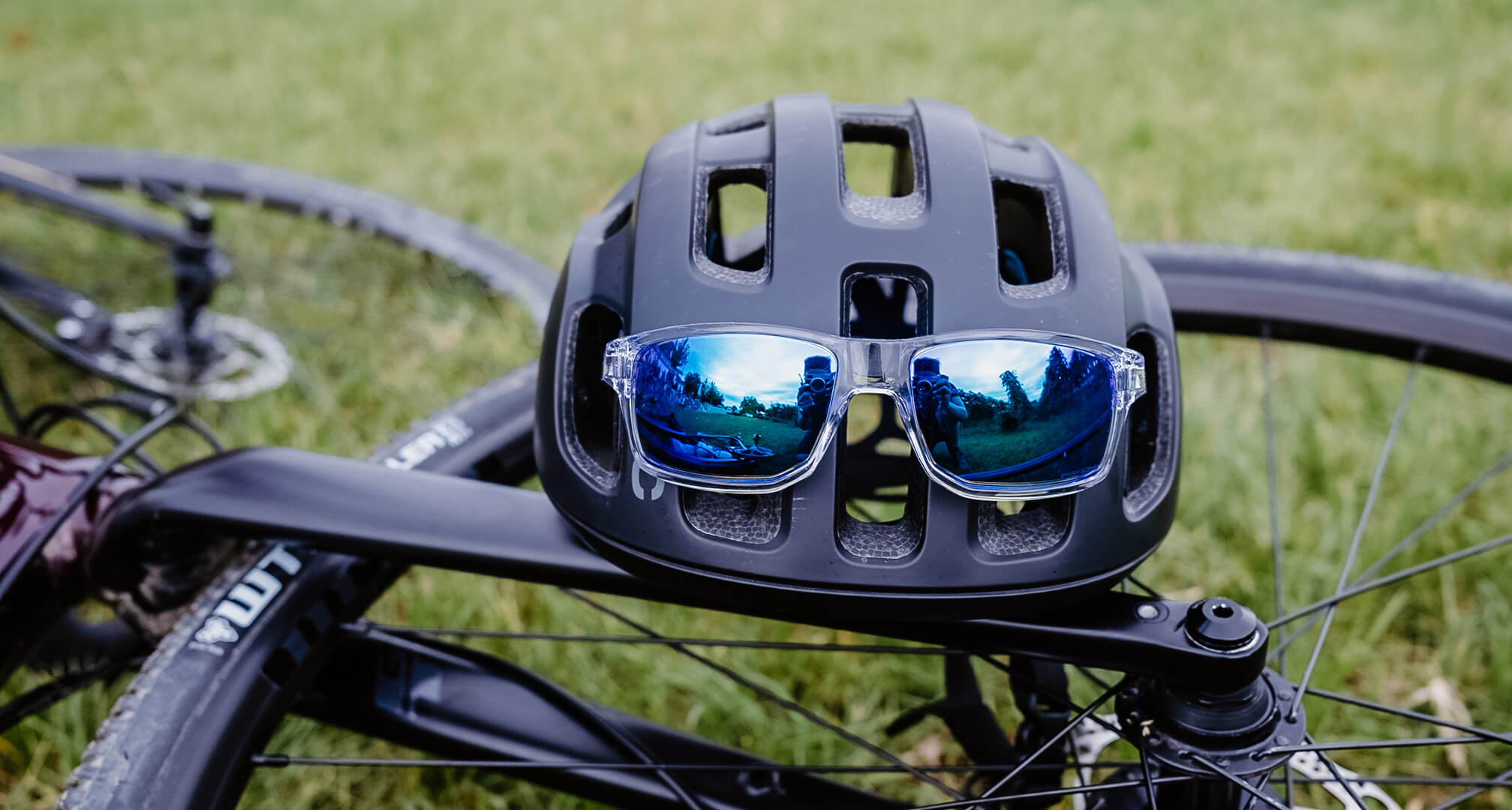 occhiali da sole a specchio blu su casco da bici con bicicletta