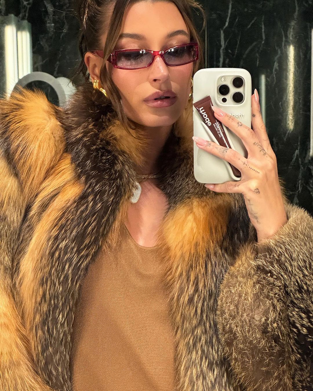 hailey bieber si fotografa allo specchio con gli occhiali da sole