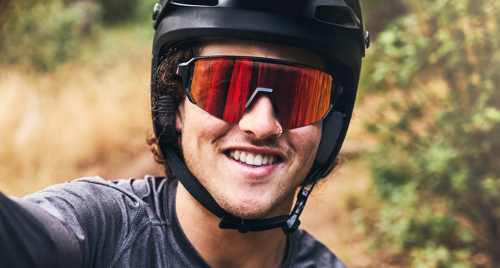 primo piano di uomo che indossa casco da mountain bike e occhiali da sole